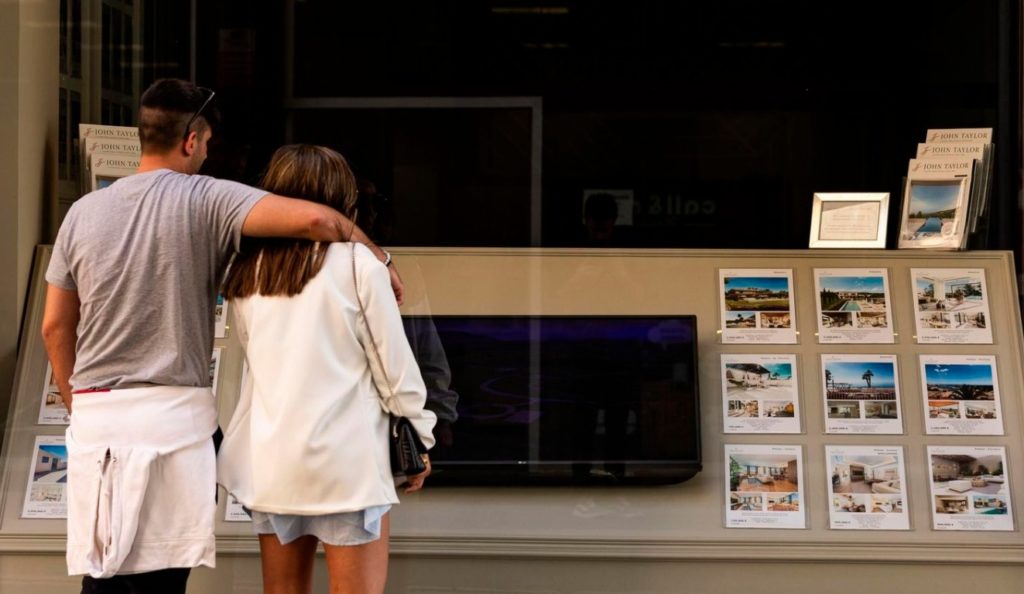 Jovenes viendo precios de casas.